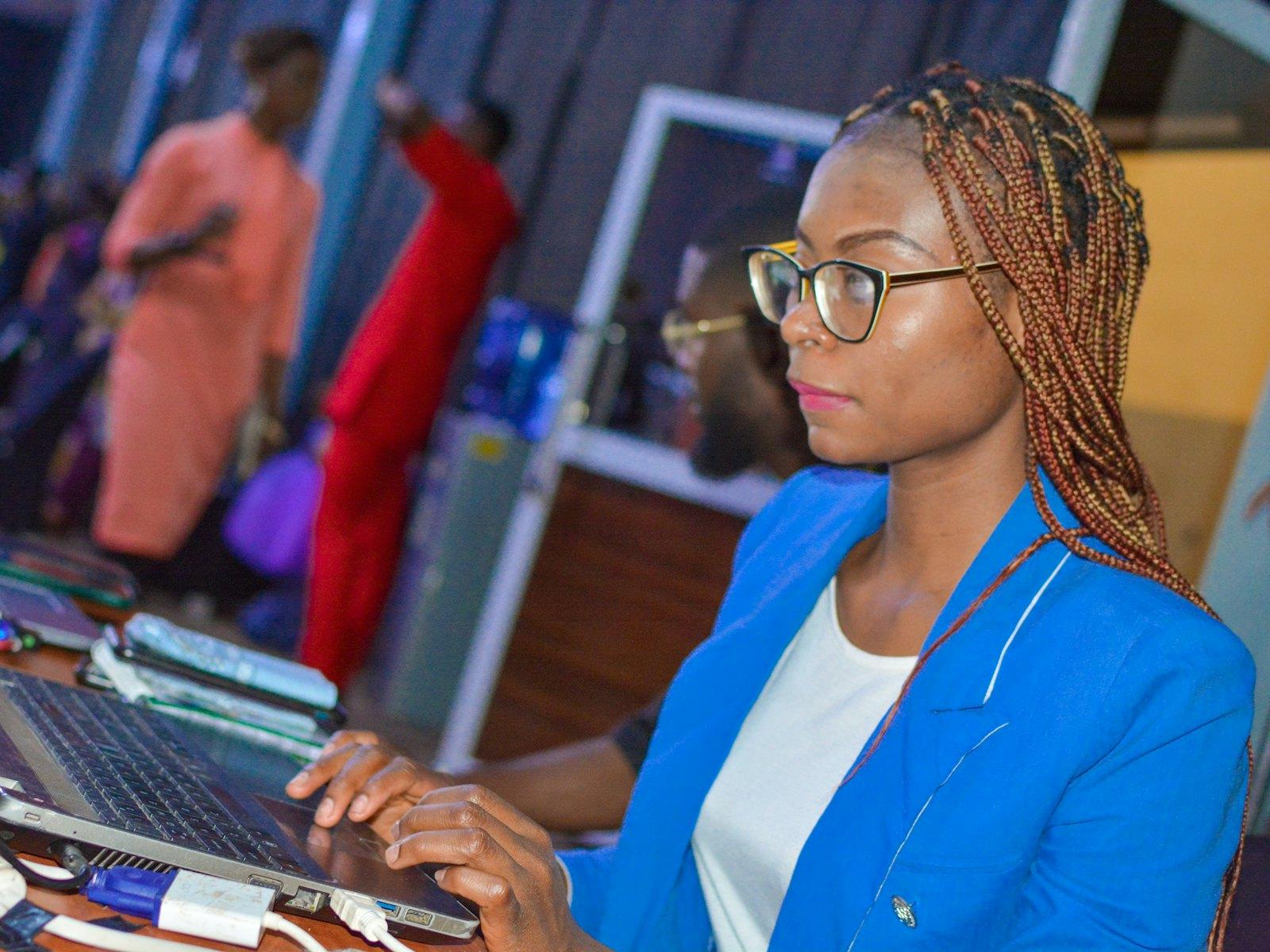 A business owner in a blue blazer working on her laptop
