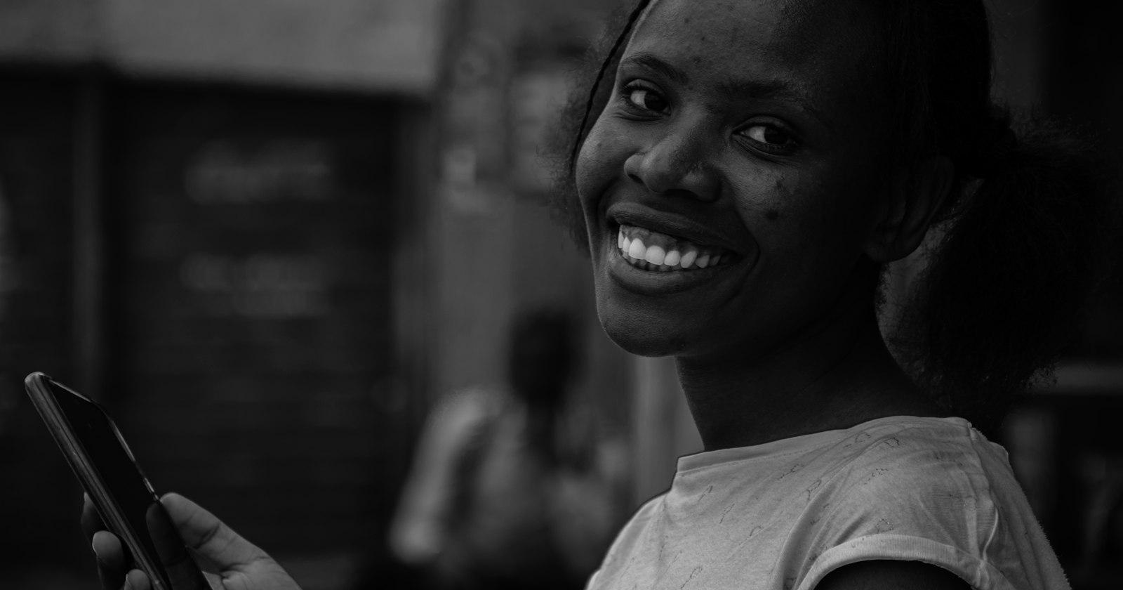 A smiling woman holding a phone